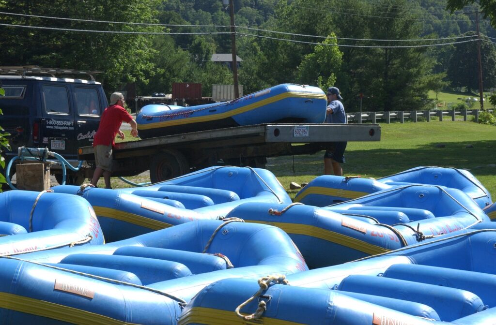 two men unloading rafts from a truck bed