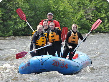 People standing a raft smiling