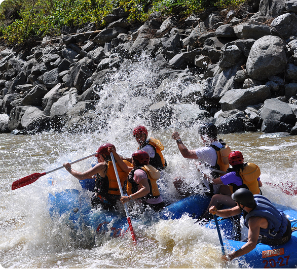 People in a raft hitting a rapid